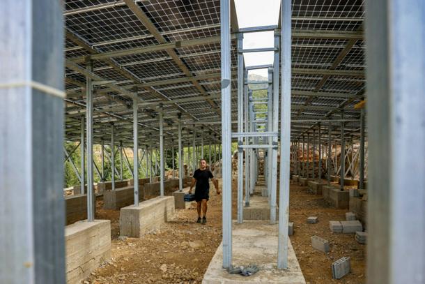 یک تکنسین روی سیستم پنل خورشیدی نصب شده برای روستای طولا در شمال لبنان کار می کند
